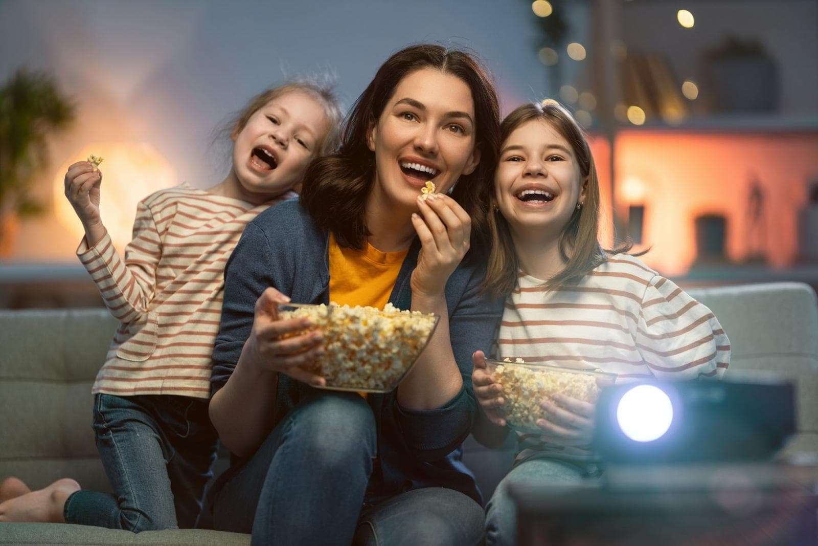 Friends with popcorn laughing during a movie night