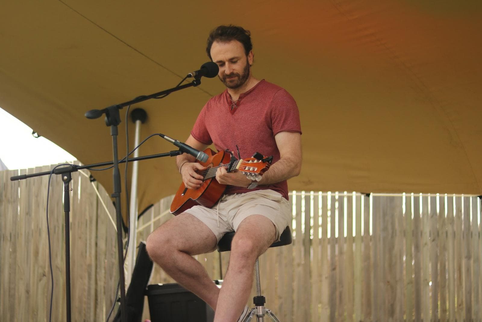 Man playing acoustic guitar and singing into a microphone