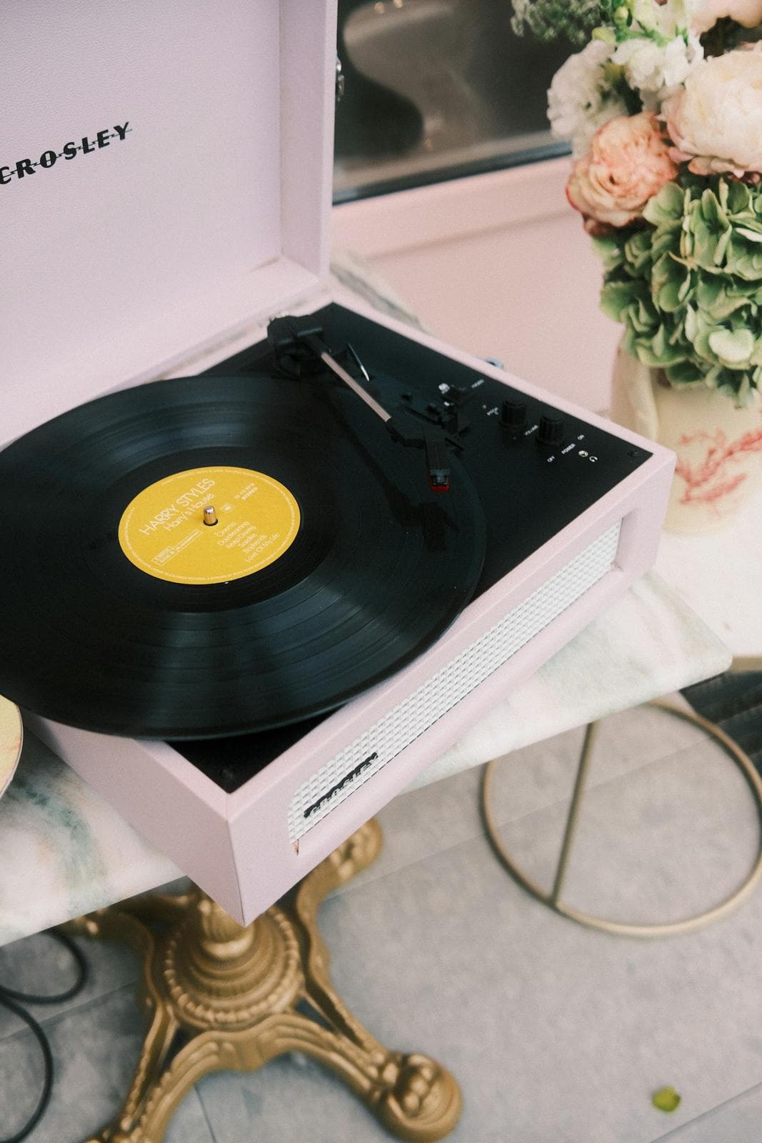 Turntable playing a vinyl record beside a plant