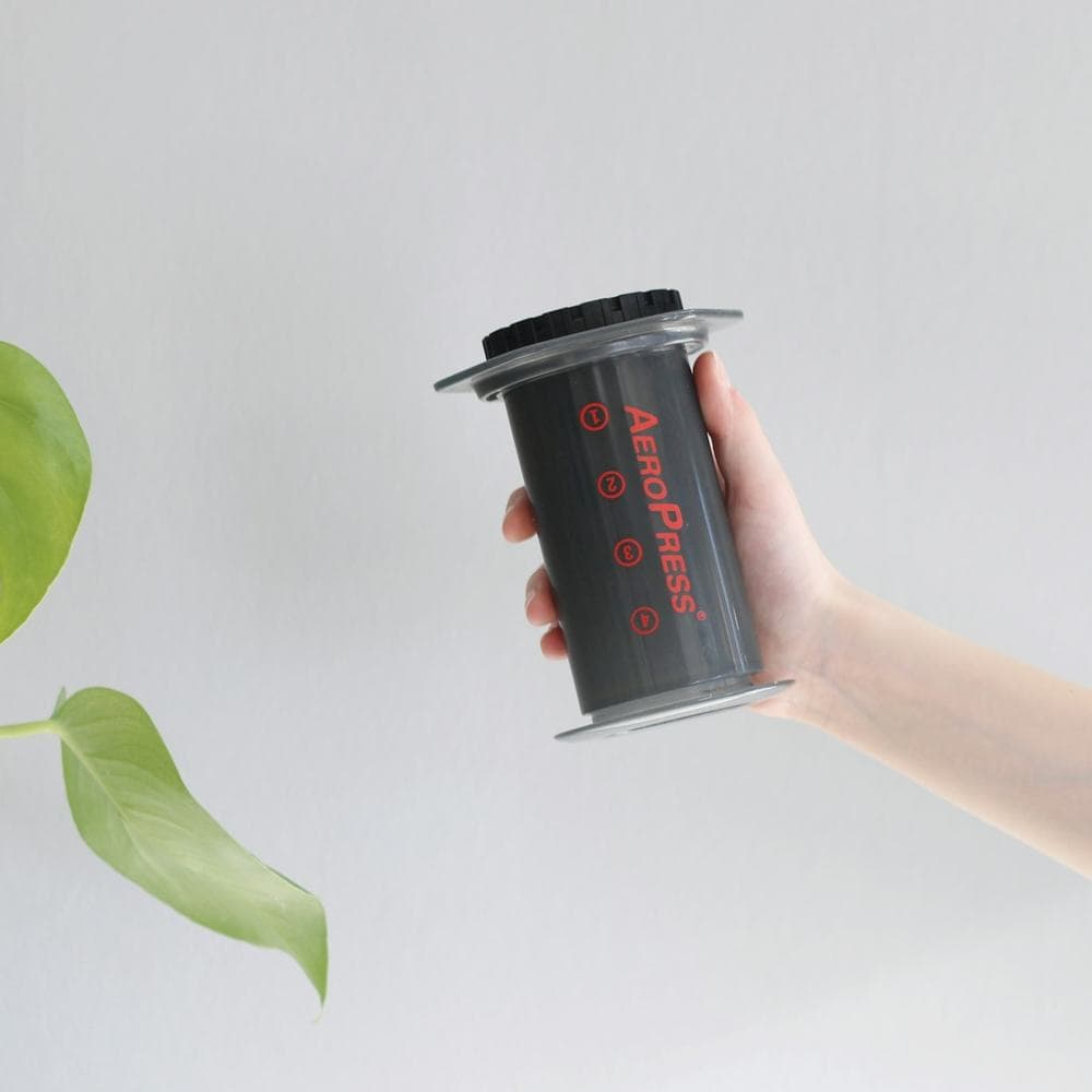 Hand holding an Aeropress brewer