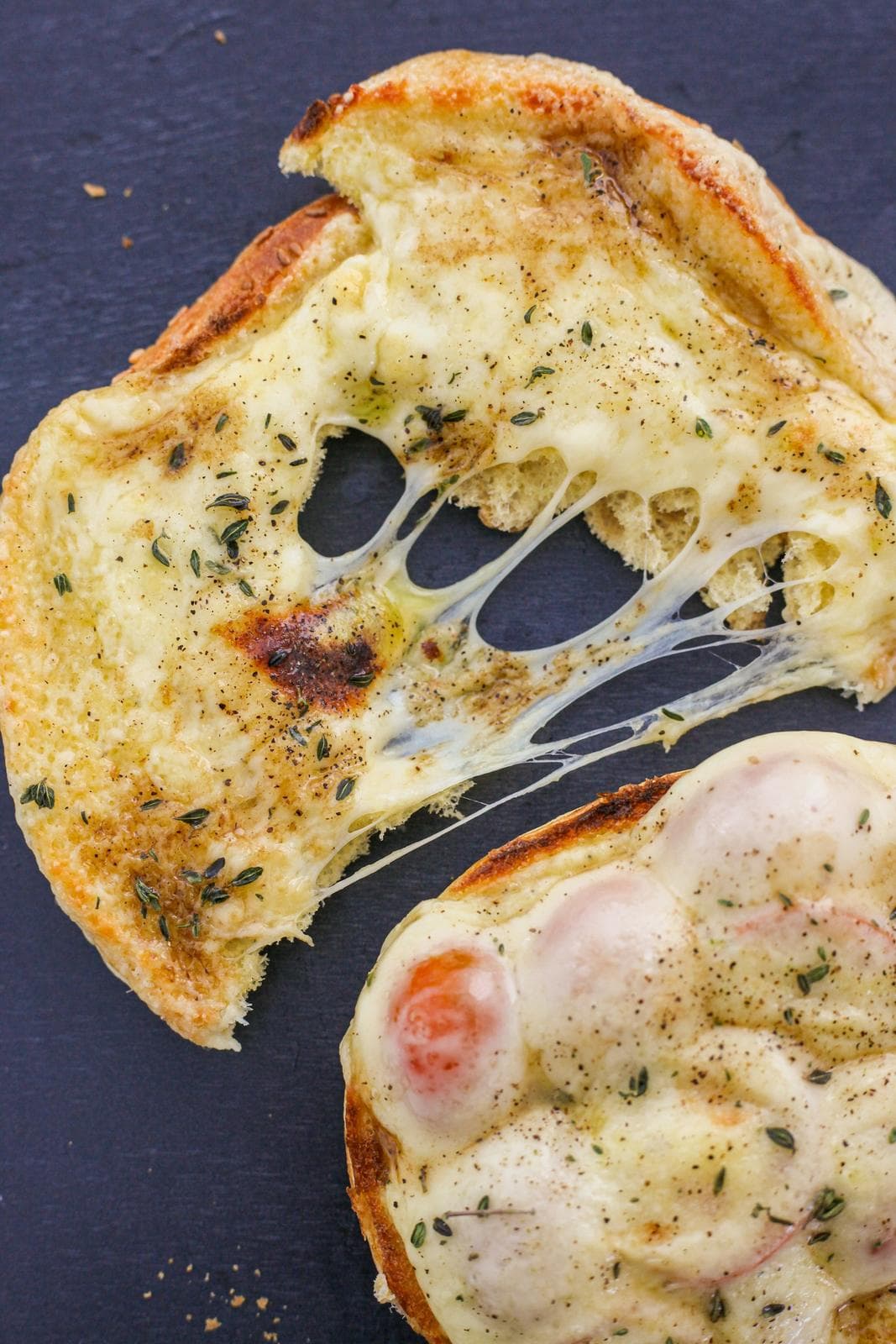 Cheese toast pulled apart with long strings of melted cheese