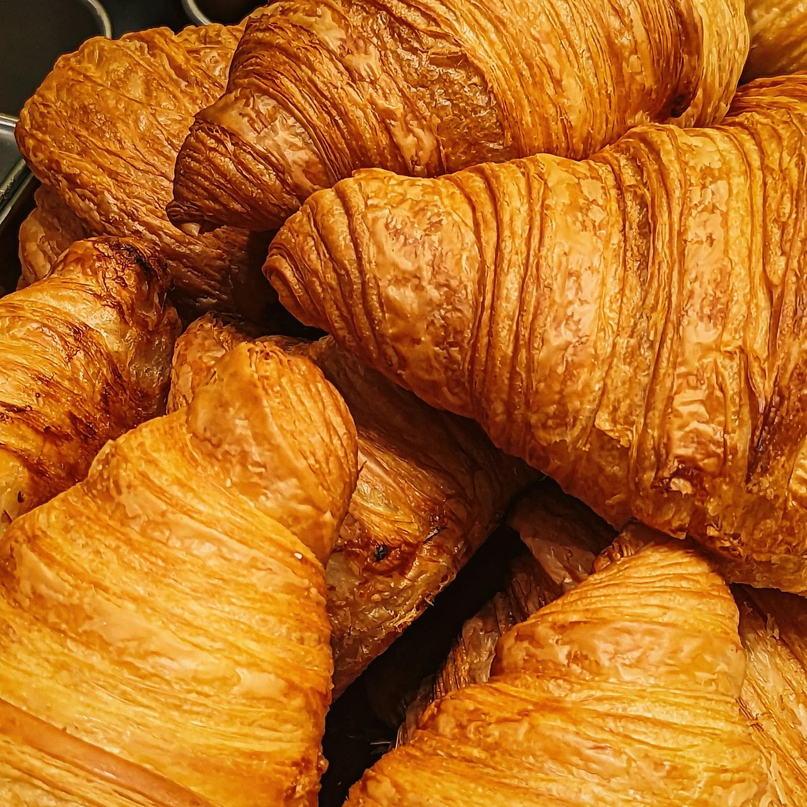 A pile of golden, flaky croissants