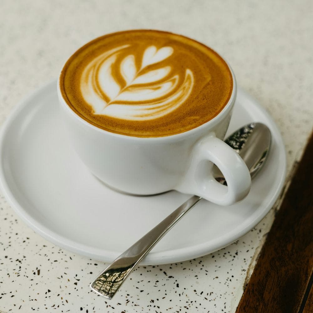 Flat white with latte art on a saucer