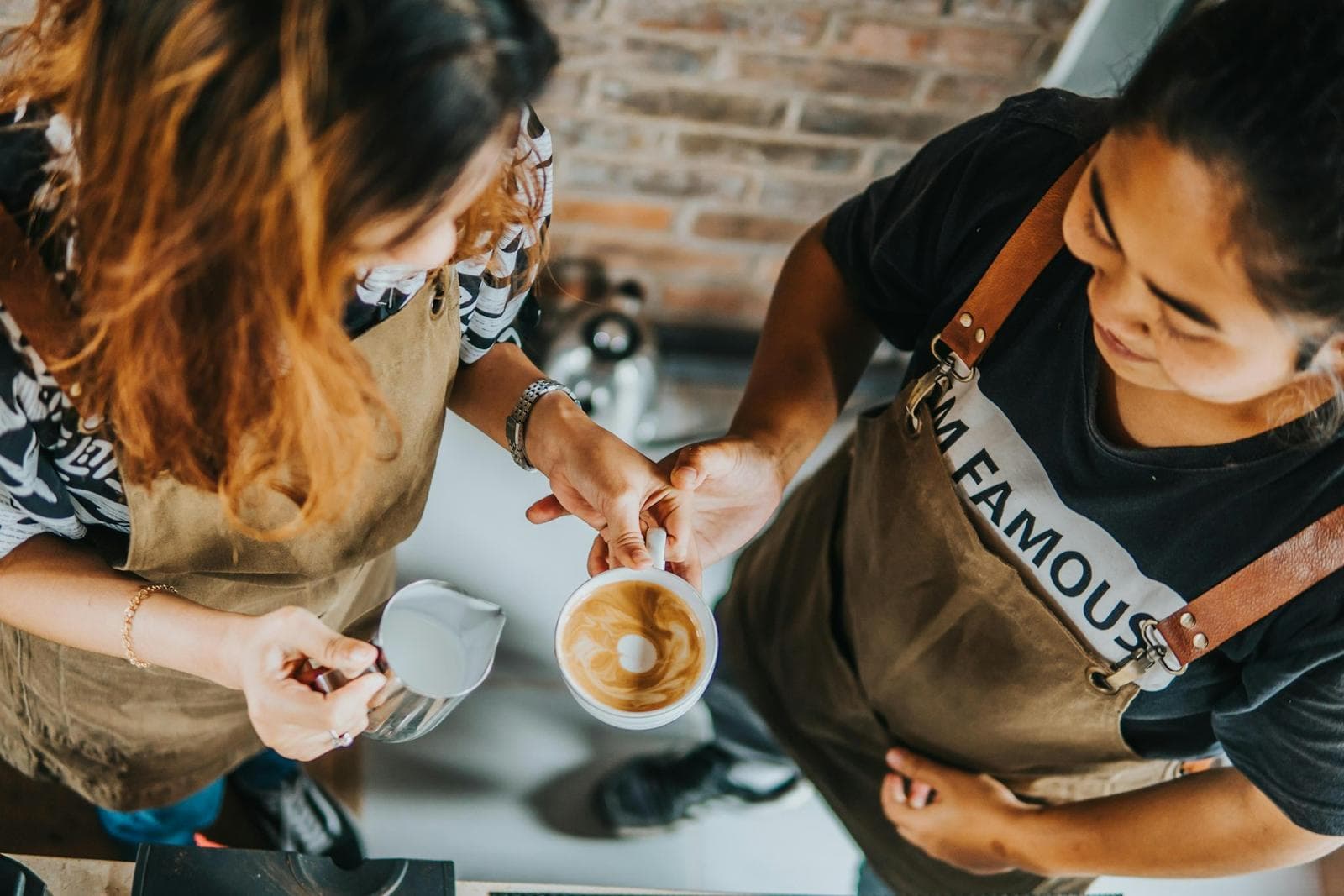 Two people practising latte art at a workshop